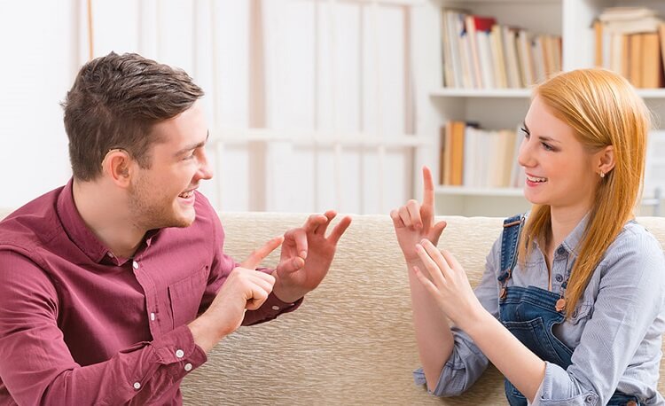 a man and a woman using sign language to talk